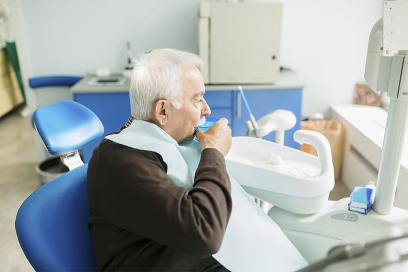 Senior man as a patient at the dentist office