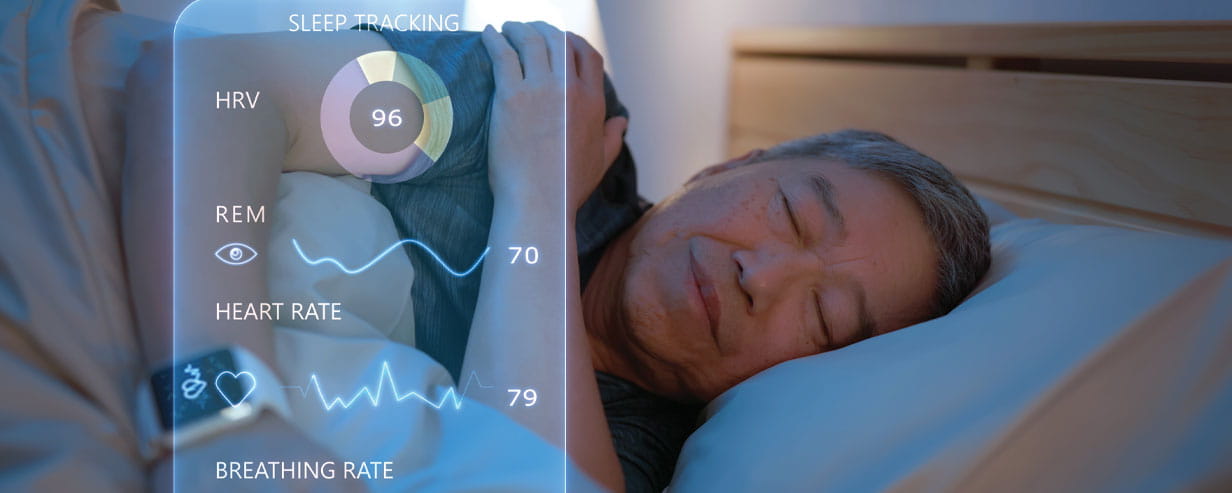 Mature man wearing a smartwatch for sleeping tracking while asleep in bed with a superimposed image of a mobile sleep app with stats sits on the left