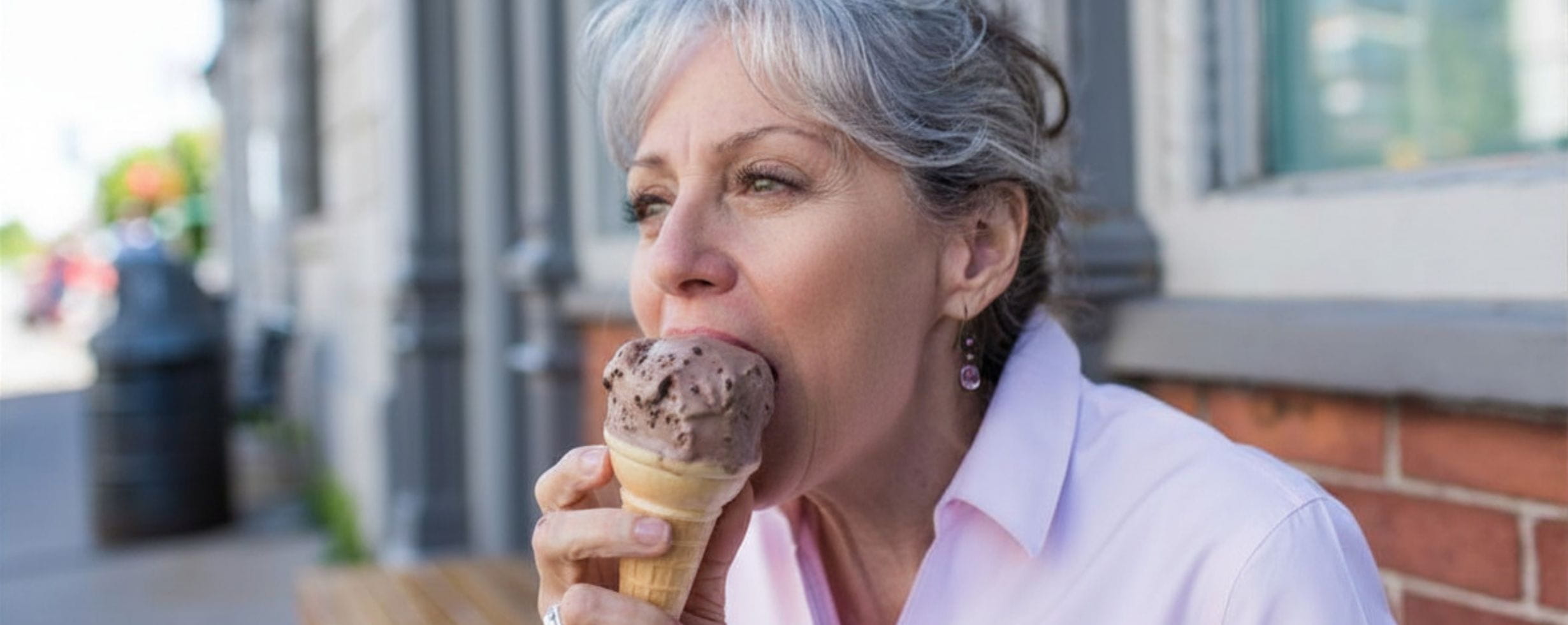 A woman enjoying eating a chocolate ice cream