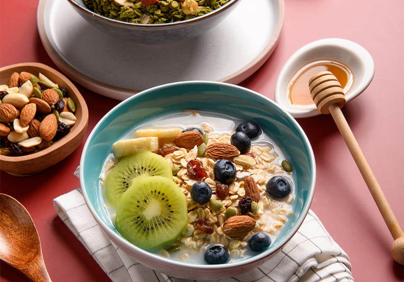 Healthy breakfast with cereal, granola, fresh berries, kiwi fruits, nuts and honey