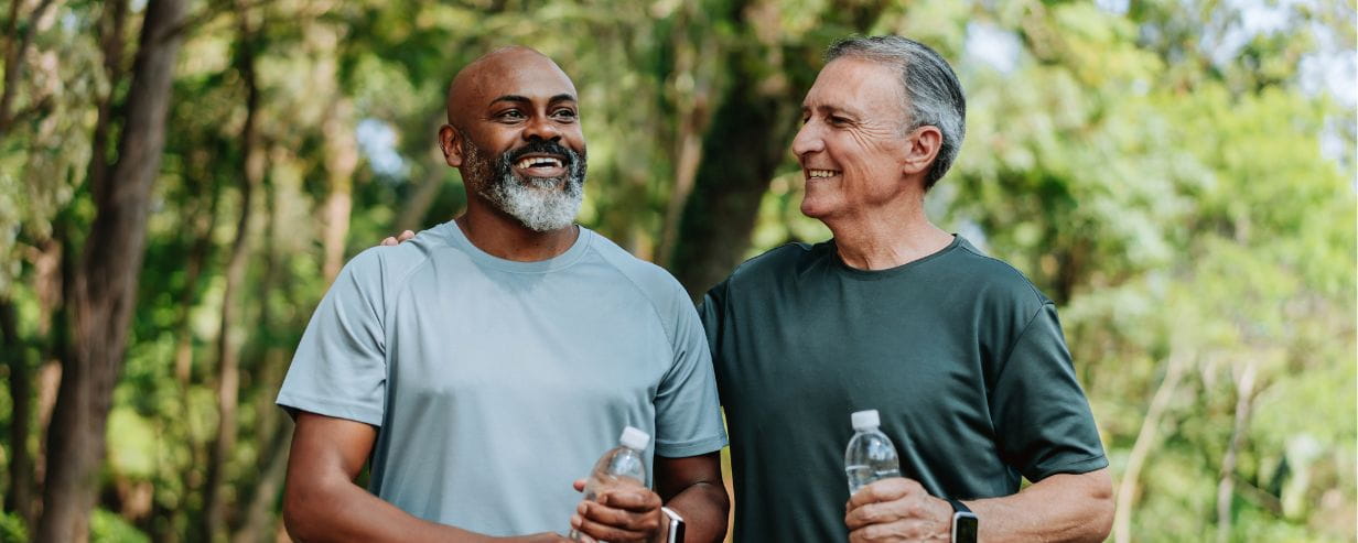 Two men holding water bottles after exercising outside