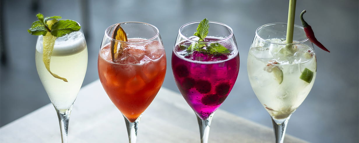 Four wine spritzers with fruit