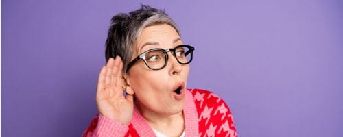 Portrait of a lady with her hand behind her ear to listen clearly