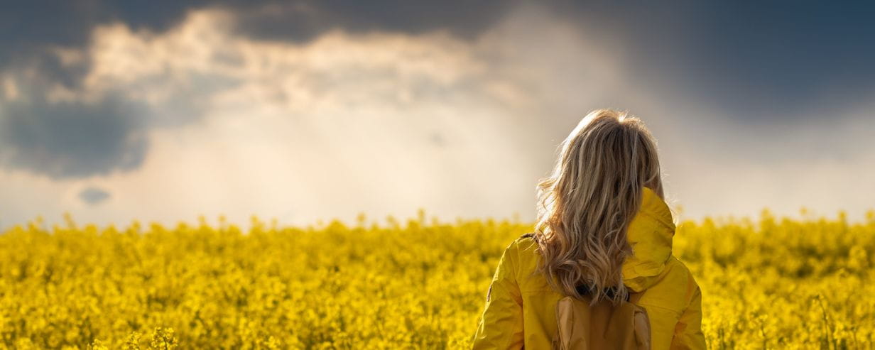 Woman in field with grey clouds foreboding