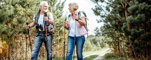 Two mature adults walking with walking sticks