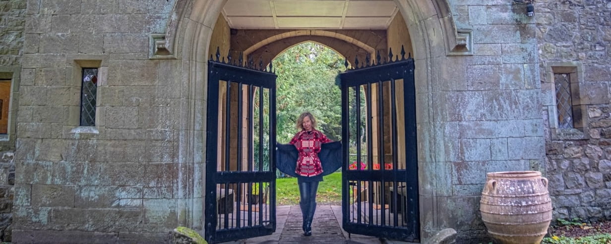 The writer holding open the giant gates to the castle where she lives