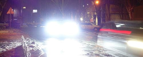 Light from car headlights on winter night