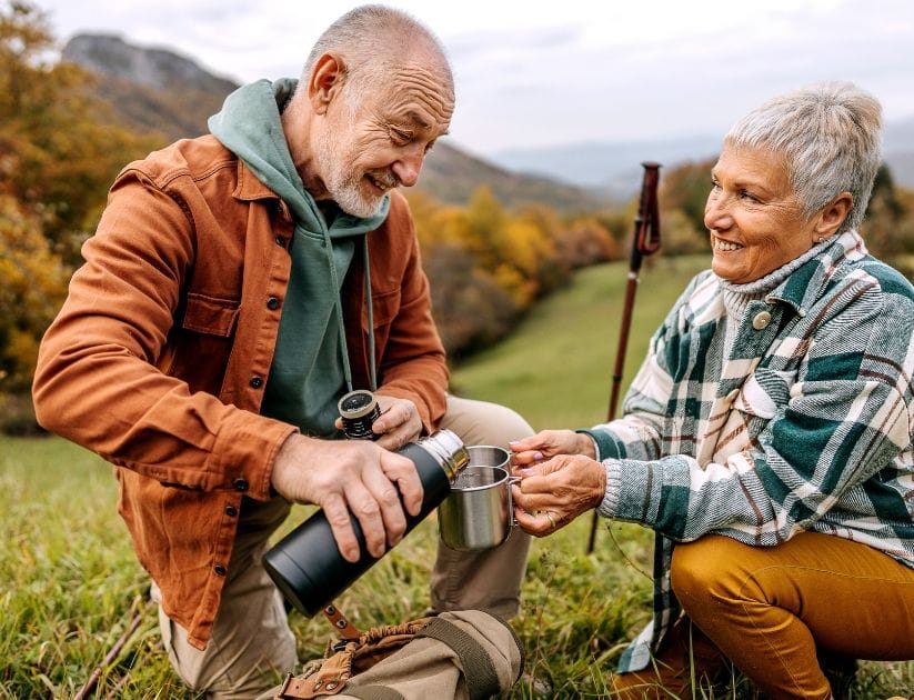 Couple outside with a survival kit drinking water