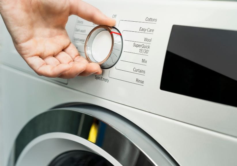 Someone choosing the washing machine programme settings