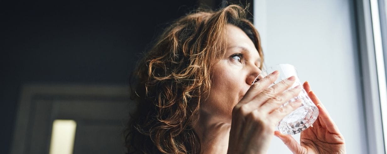 Woman drinking fresh water from a glass