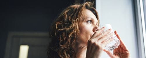 Woman drinking fresh water from a glass