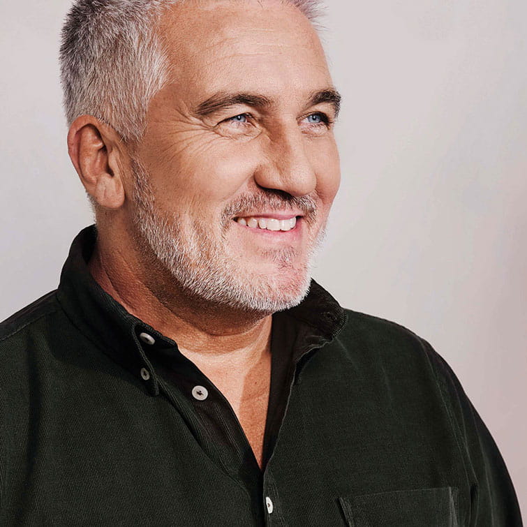 Head and shoulders portrait of Paul Hollywood facing to the right and wearing a black shirt