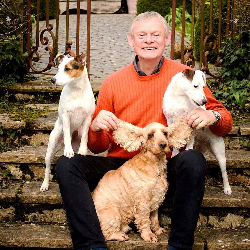 Martin Clunes with three of his dogs in his garden