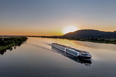 Saga river cruise ship Spirit of the Lorelei on a river at sunset