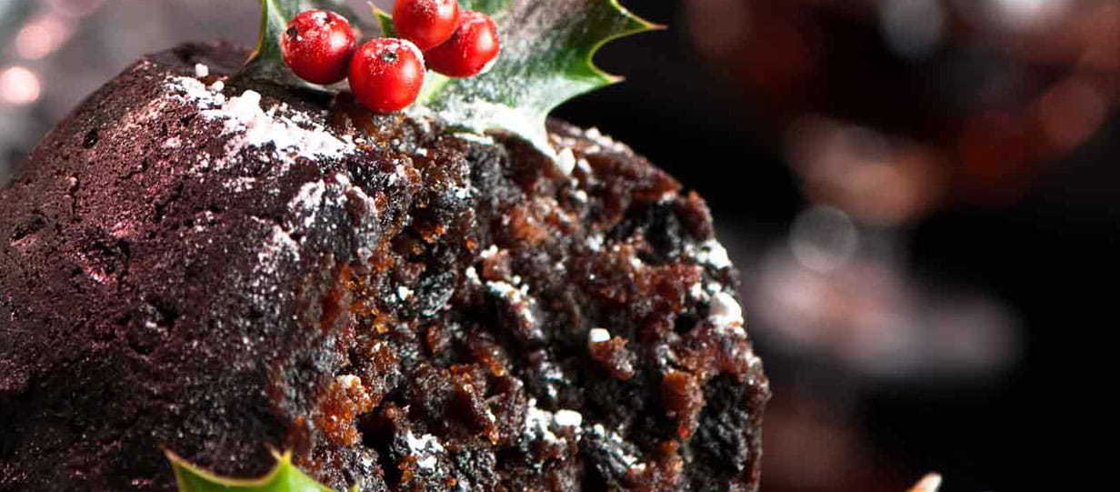 Figgy pudding topped with holly leaves and berries