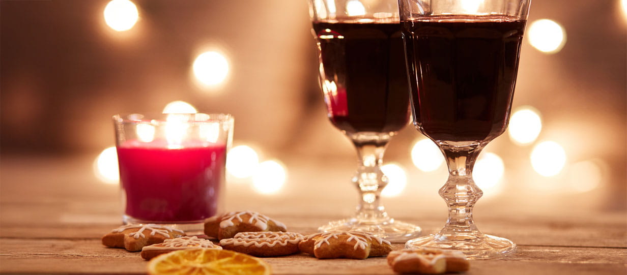Glasses of Glogg beside festive cookies and candles