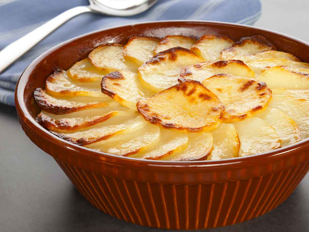 Browned potato slices in a deep round dish