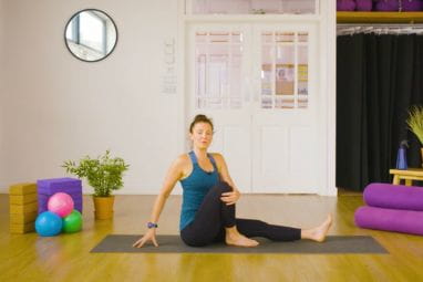 A yoga teacher demonstrates a twist to help gut health