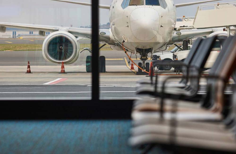 A view of a plane outside the window of the boarding waiting area