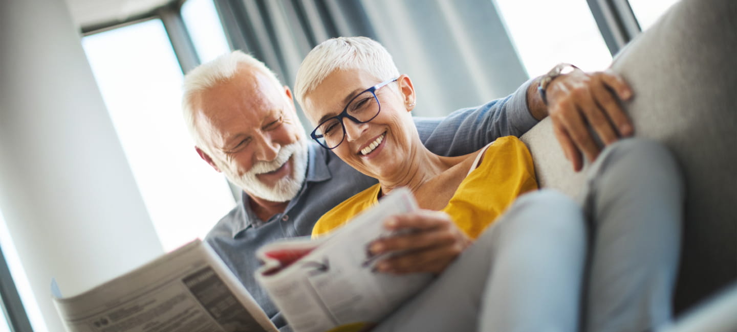 A couple reading the Saga Equity Release guide on the sofa