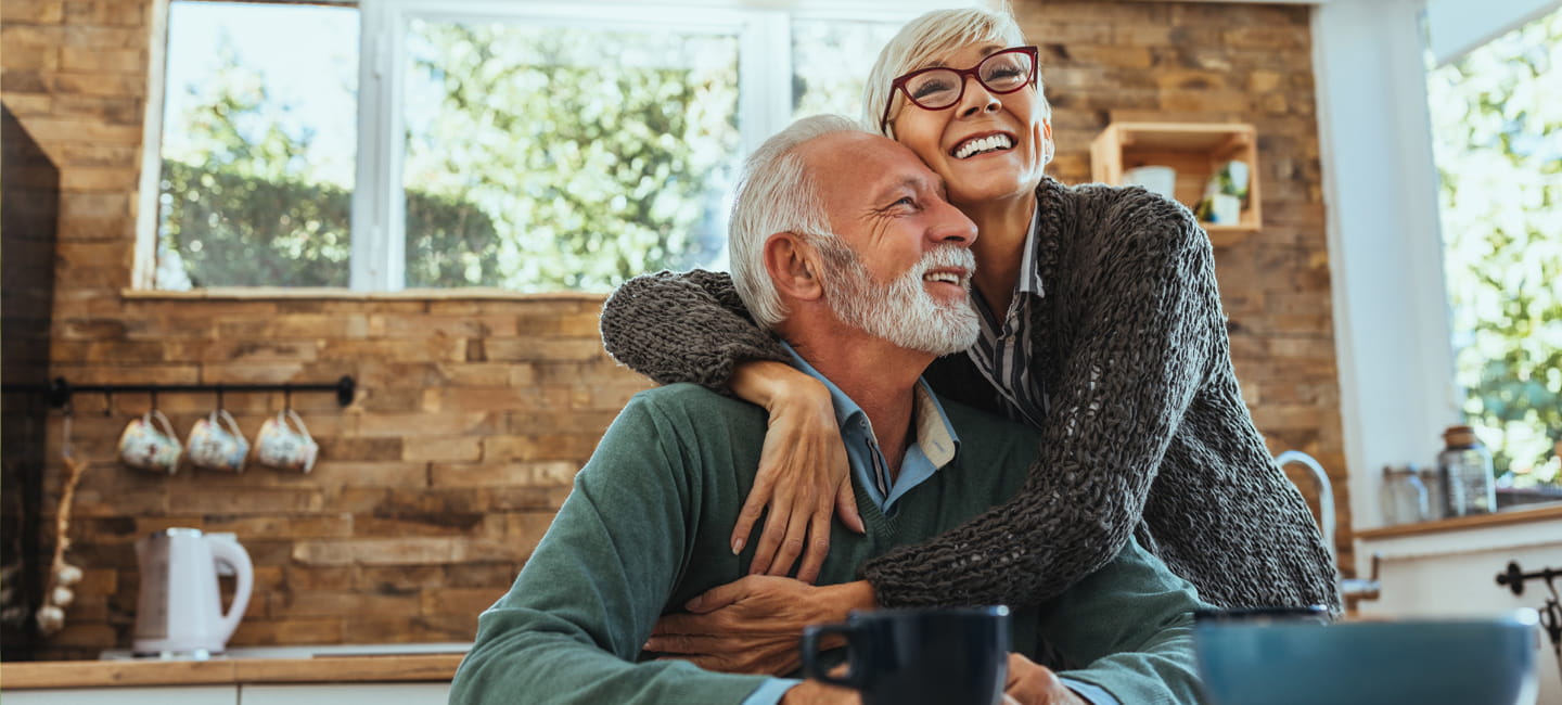 Two people in a kitchen hugging and smiling