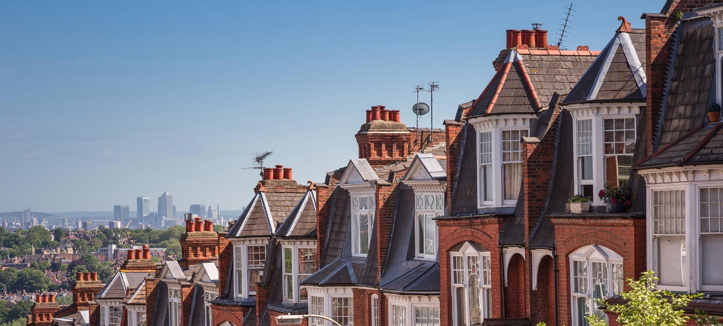 A row of houses with a view of a big city in the distance