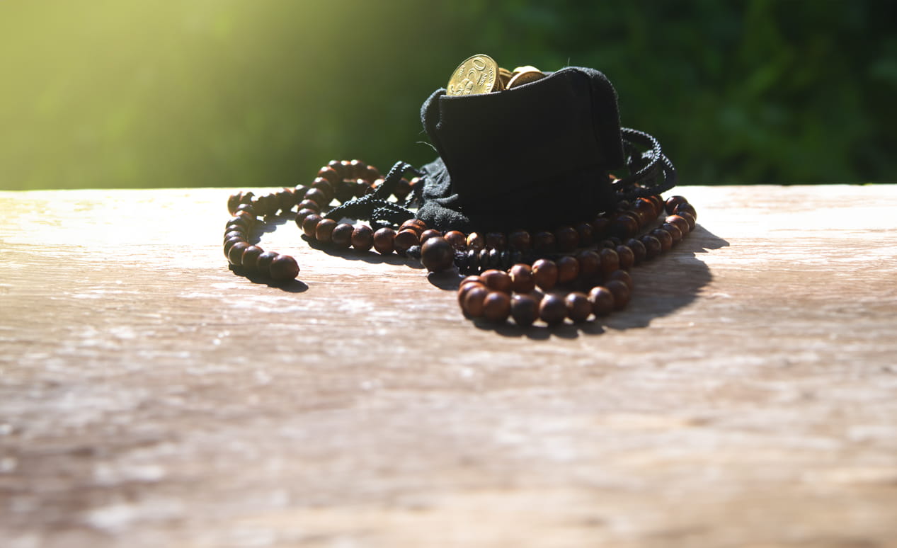 A small bag of coins and some prayer beads