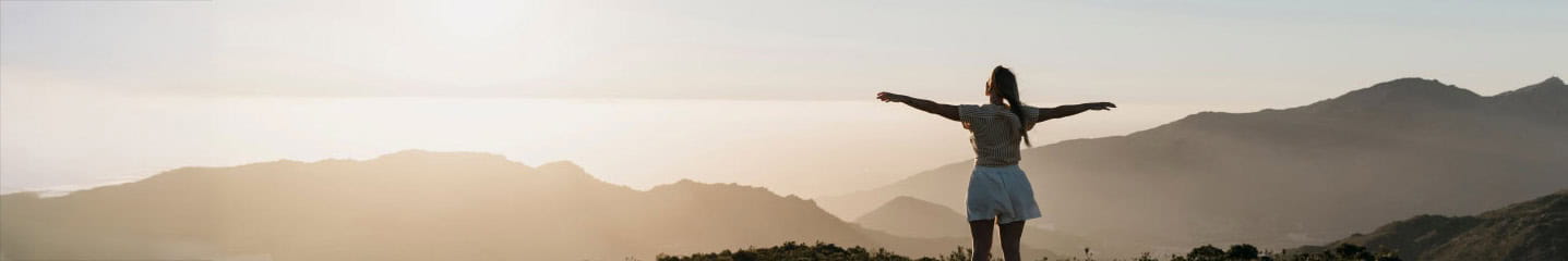 A woman looking across at a mountain range
