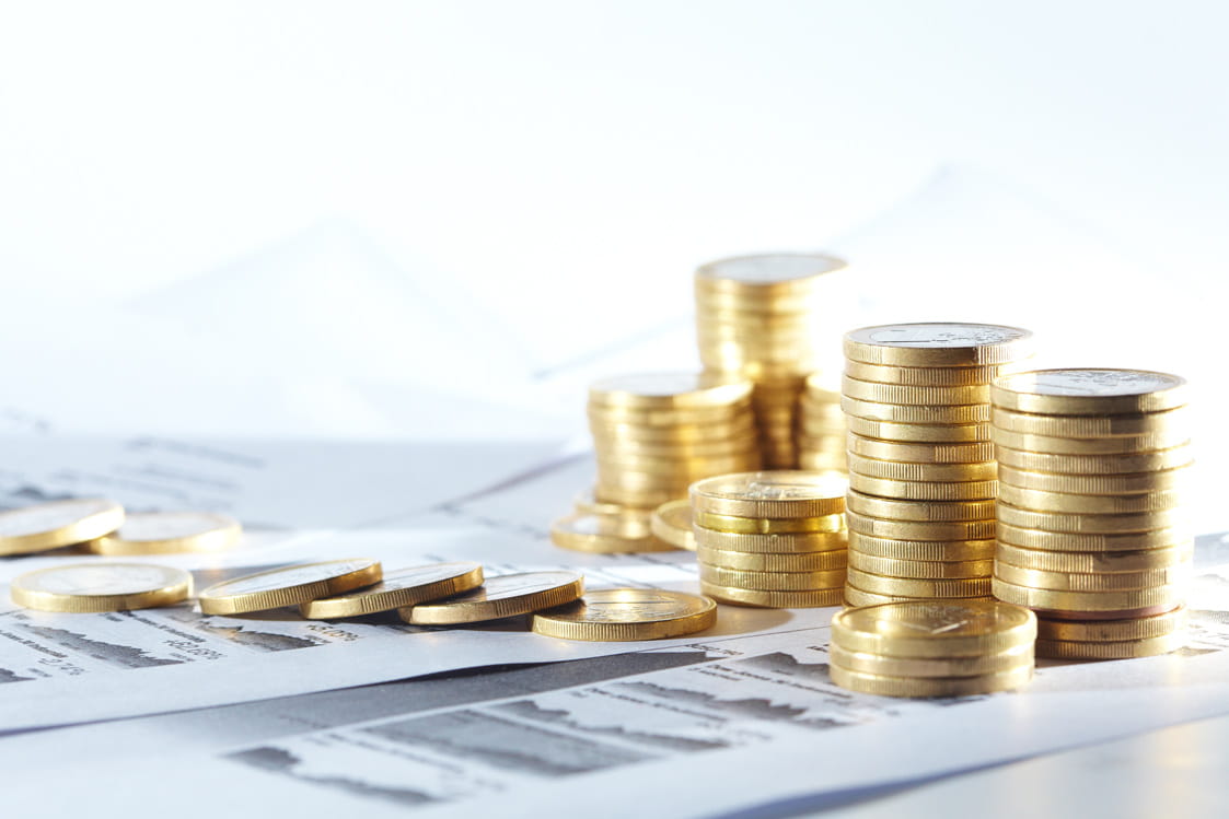 PIles of coins over financial papers