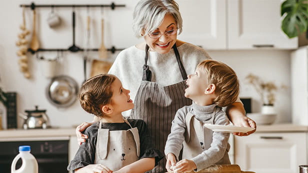 A grandmother with her grandchildren at home in the kitchen