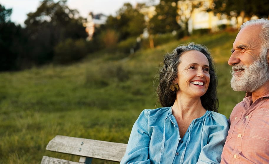 Mature couple relaxing on a park bench in the evening