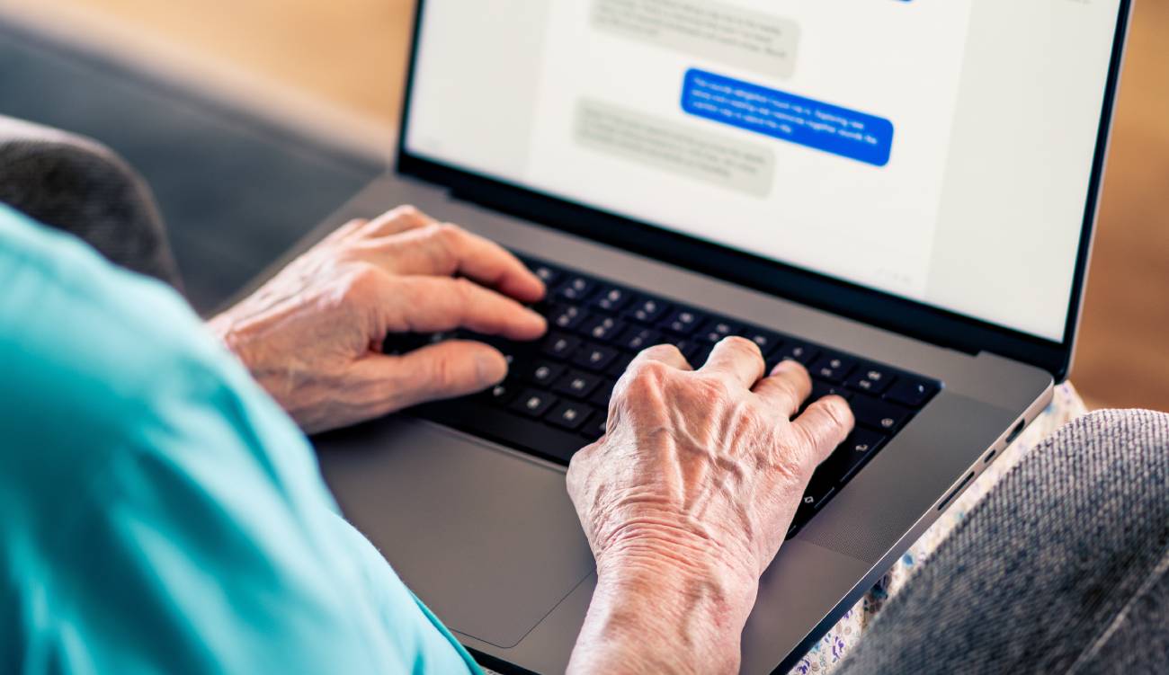  Elder senior using computer using instant messaging on a laptop