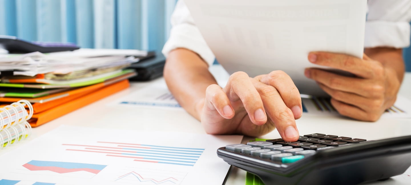 A person typing in to a calculator