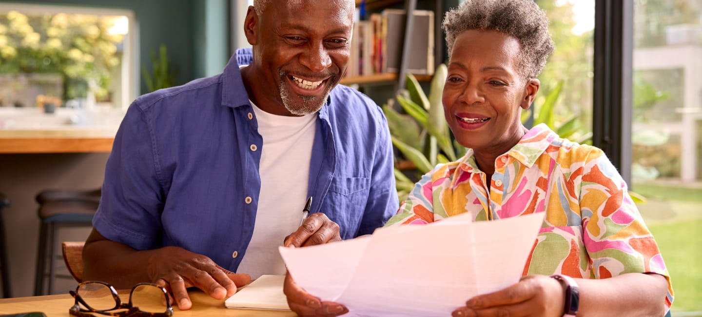 A smiley couple looking at some paperwork