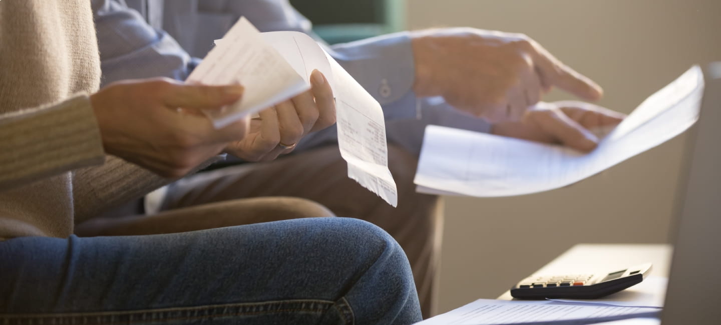 People sat on the sofa holding lots of paperwork