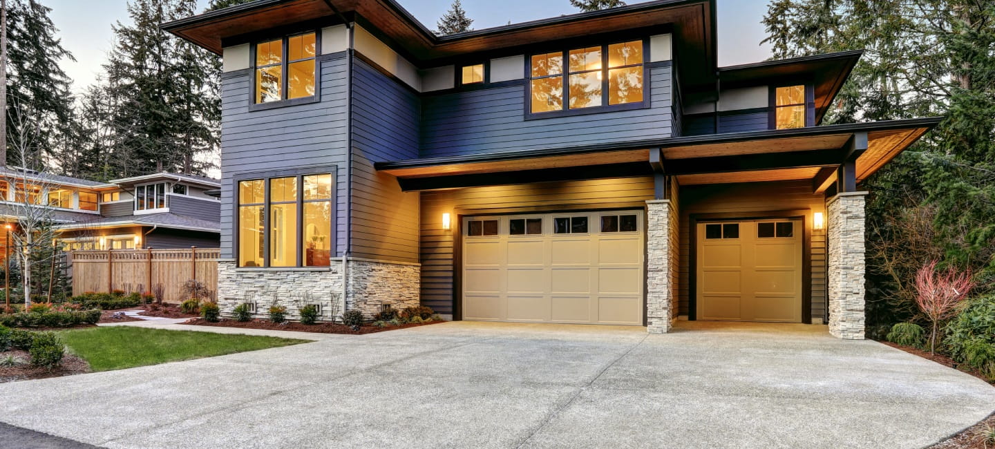 A large and impressive looking home with two garages and a huge driveway