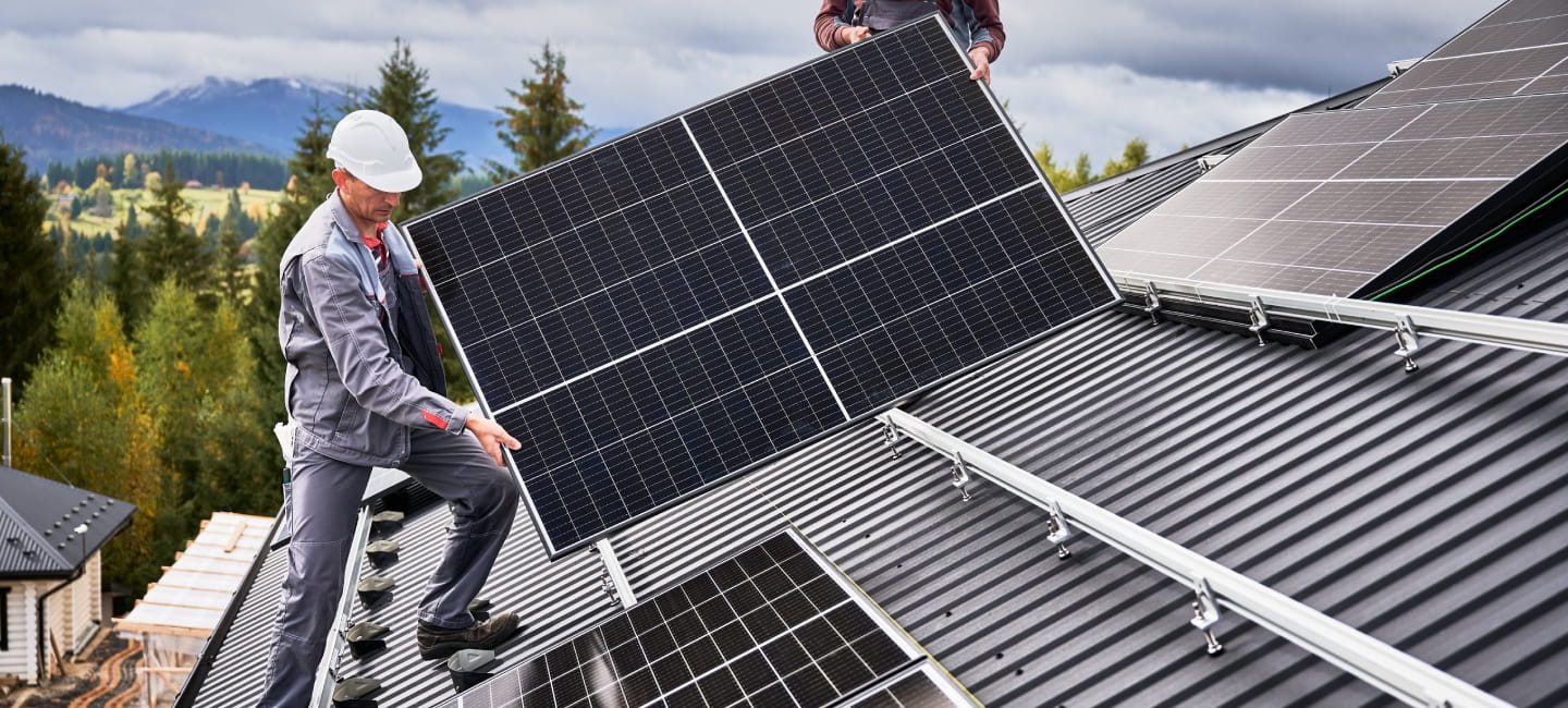 A man is installing solar panels on a roof