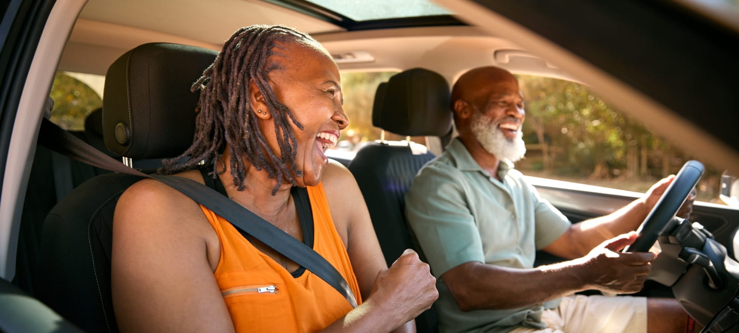 Senior Couple Enjoying Summer Day Trip Out Driving In Car Together