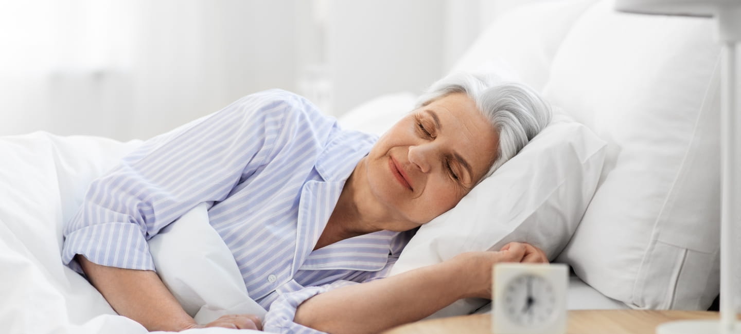 Old age and people concept - senior woman sleeping in bed at home bedroom