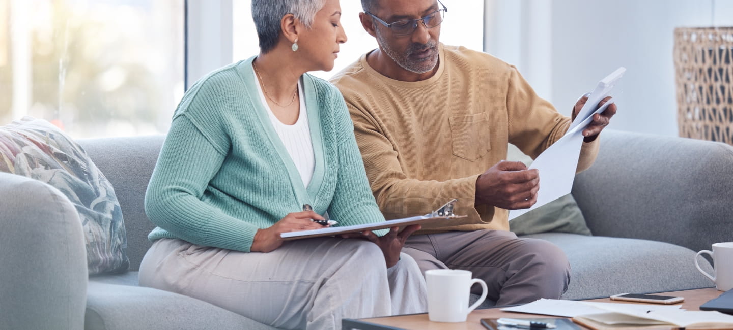 Finance, documents and senior couple on sofa with bills, paperwork and insurance checklist in home, life or asset management, Elderly black people on couch with financial, retirement or mortgage debt