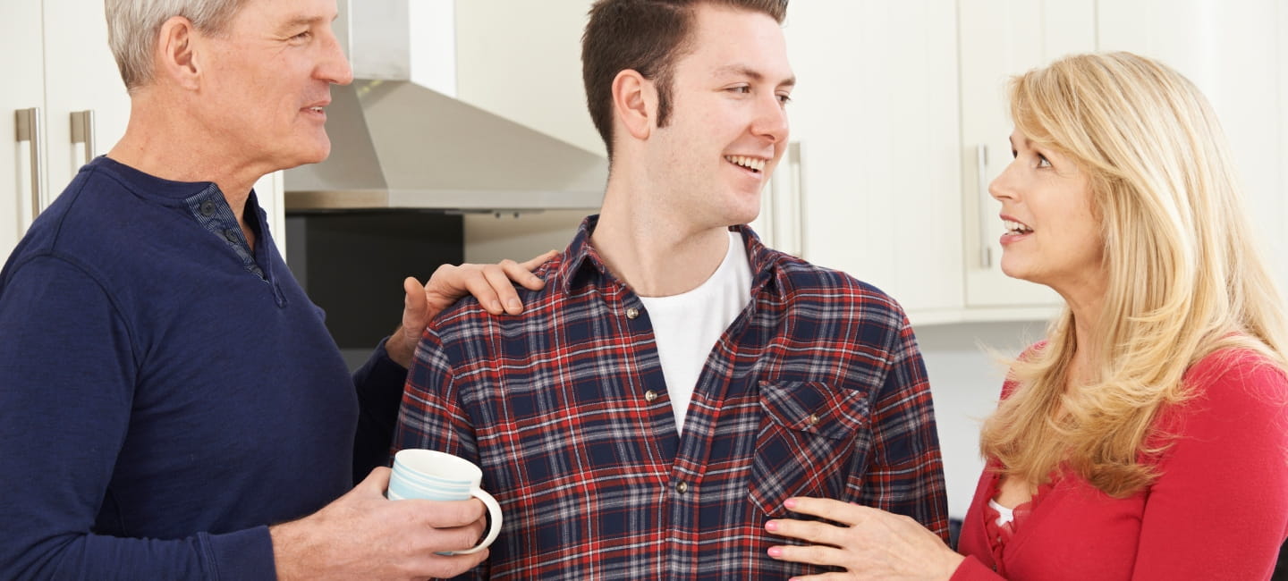 Portrait Of Family With Adult Son At Home.