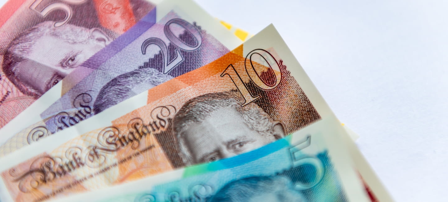 Updated Pound Sterling bank notes with the King's portrait isolated in a white background.