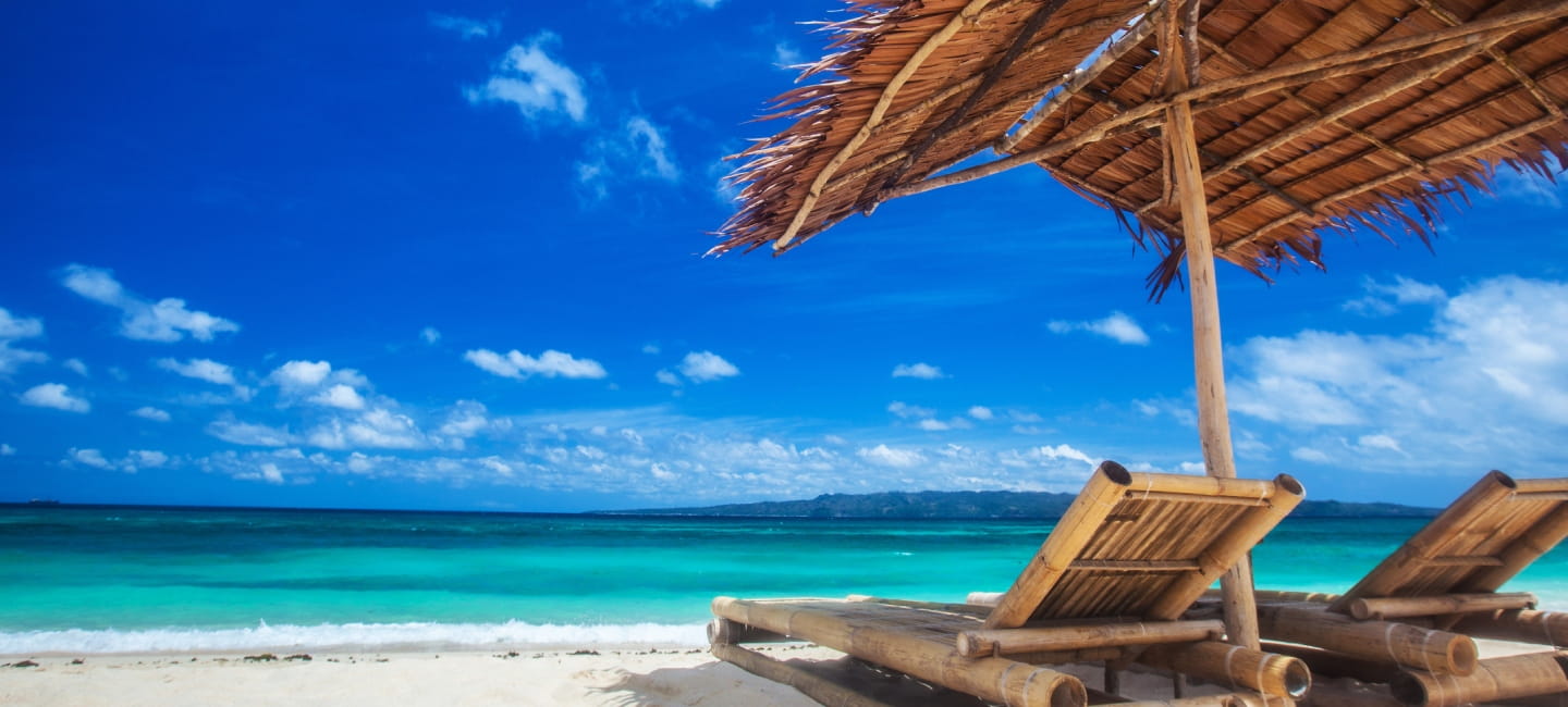 Beach chairs and umbrella on a beautiful tropical sea beach, view with copy space.