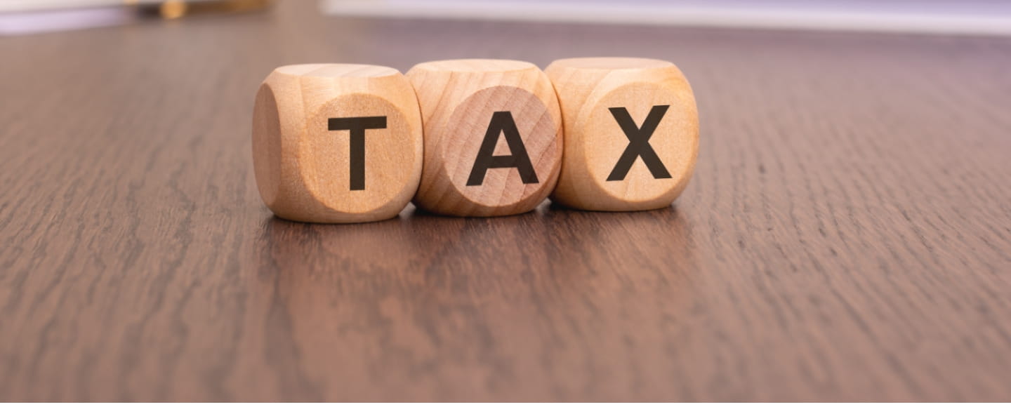 Word TAX written on wooden cubes. Tax concept