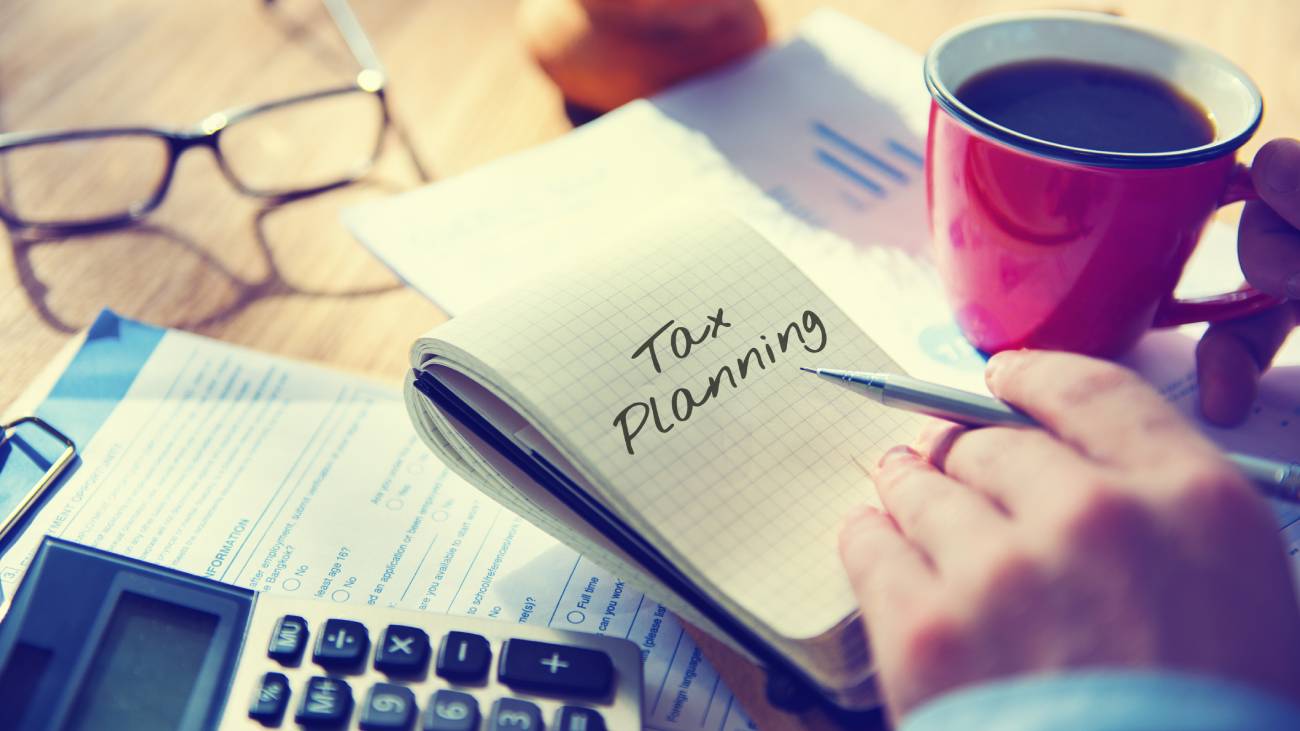 notepad with the planning written on it, with a red cup of coffee on the side