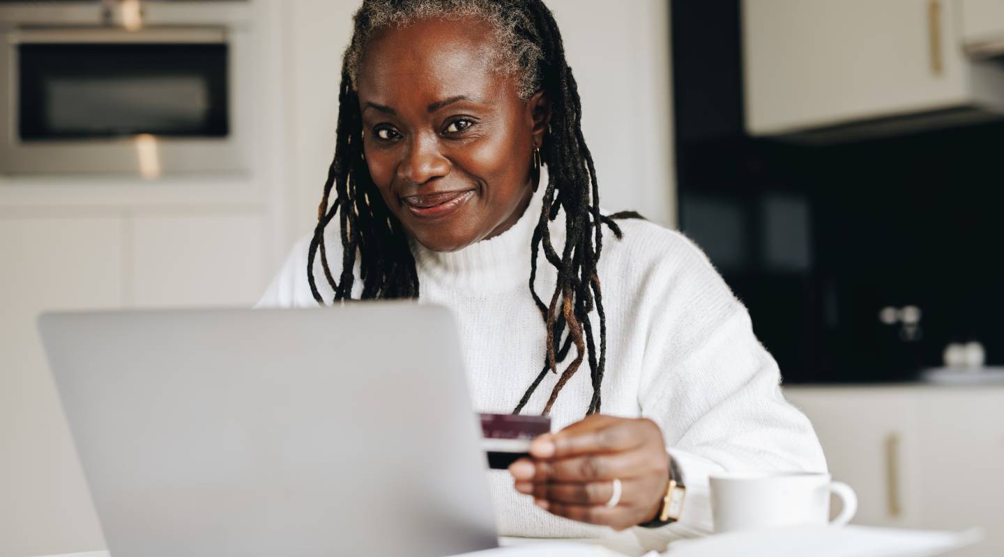 A mature woman on a laptop using her credit card