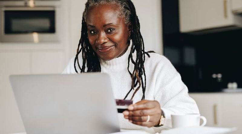 A mature woman on a laptop using her credit card