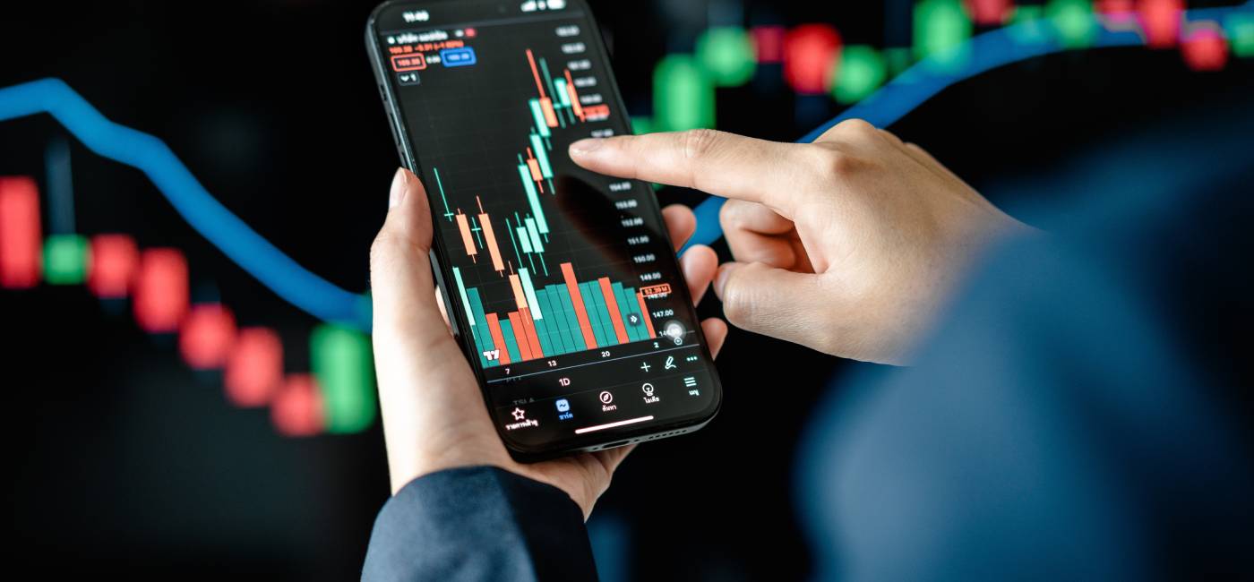 Investors analyse the data stock market index via smartphone screen to trade the stock chart for planning investments.