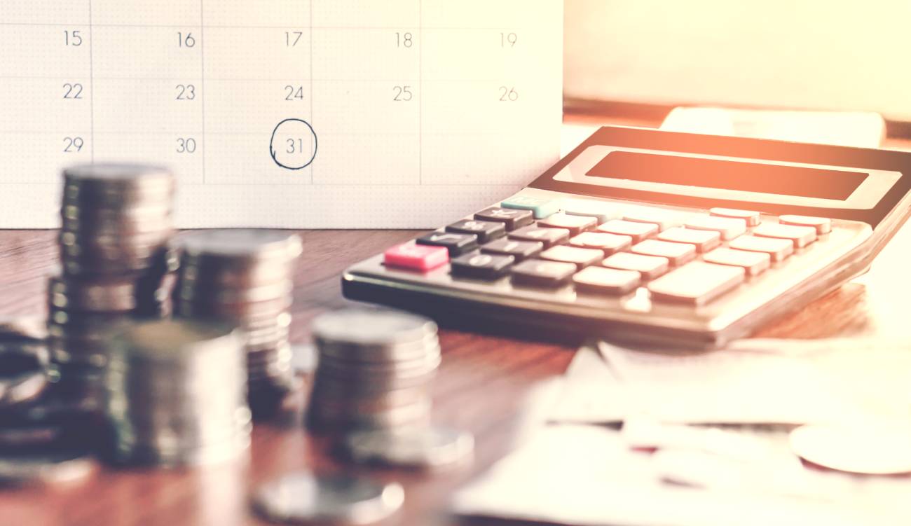  debt collection and tax season concept with deadline calendar remind note,coins,banks,calculator on table, background ,time to pay concept 