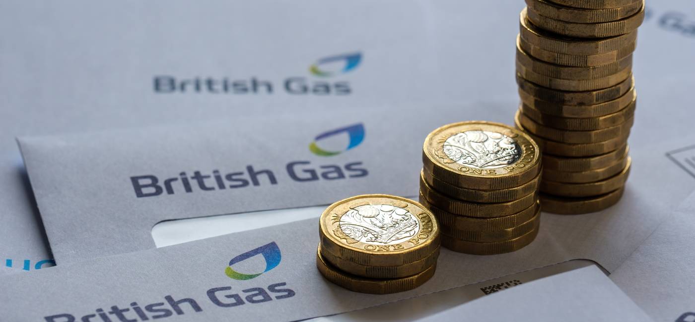 Stacks of One Pound coins on top of British Gas bills in the envelopes. 